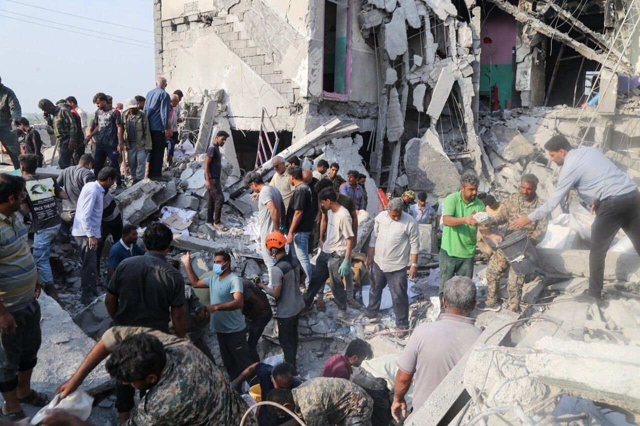 Rescuers and residents searching the rubble of the destroyed Shajareh Tayyebeh elementary school in Minab