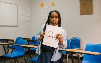 child with a sign that says stop bullying