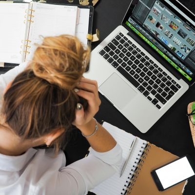 Work overload - woman sitting at desk stressed