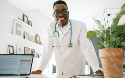 a doctor smiling while leaning on the table