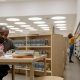 man in brown suit jacket writing on table inside the library