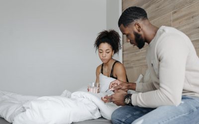 man in long sleeve shirt sitting beside woman in black tank top