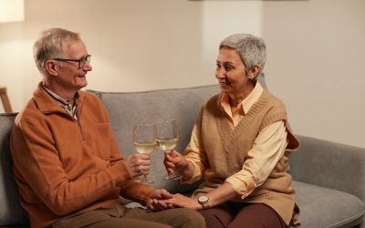 couple holding each other s hands while holding a wine glasses
