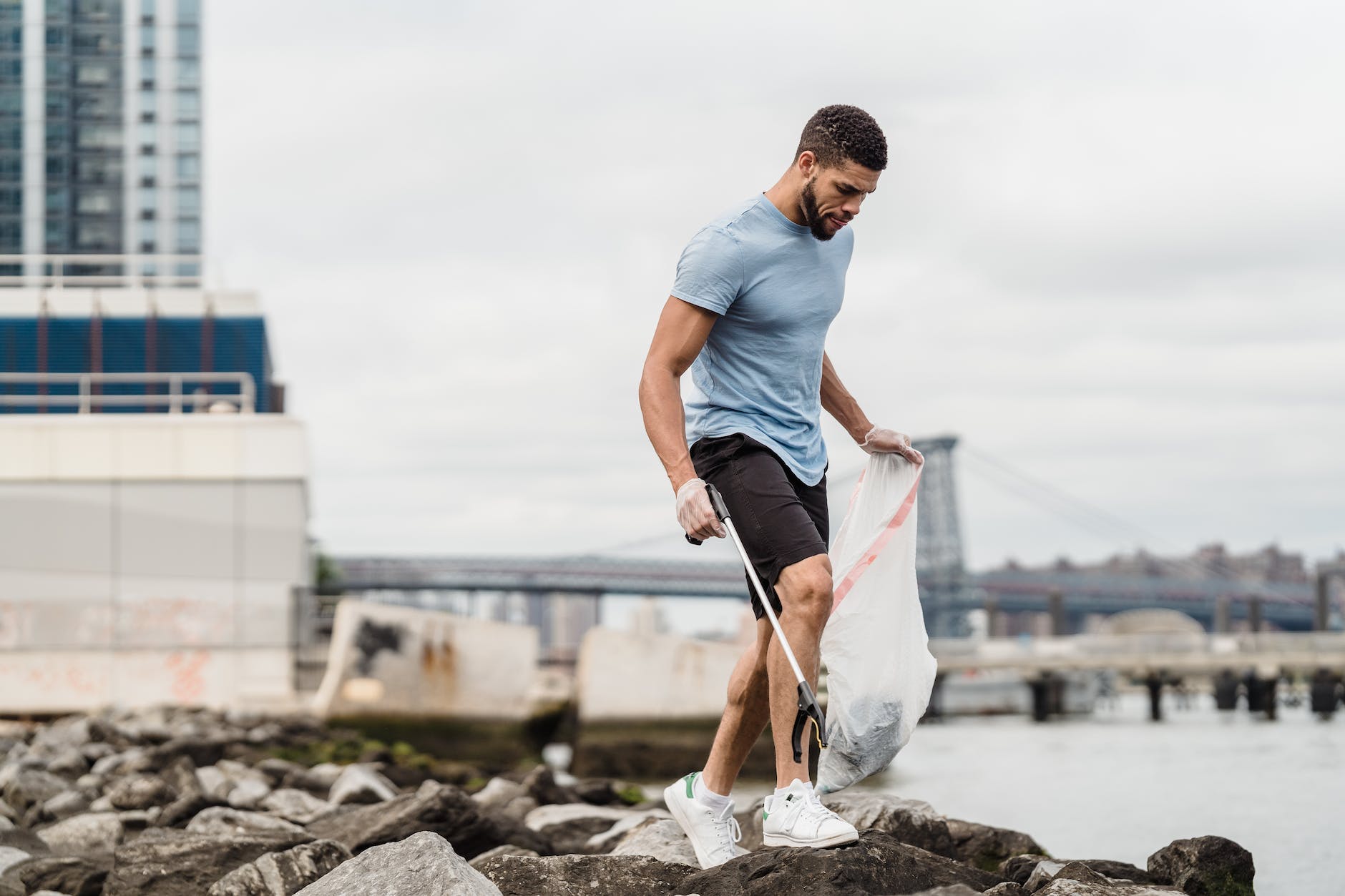 man in blue crew neck t shirt and white pants holding white textile